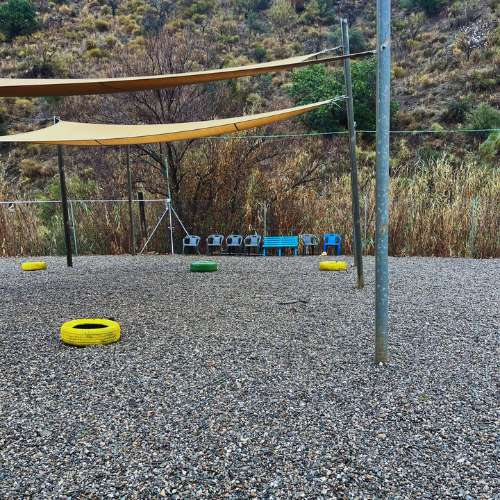 Área recreativa al aire libre en la Residencia Canina Mi Casa en Málaga, equipada con sombra y elementos de juego.