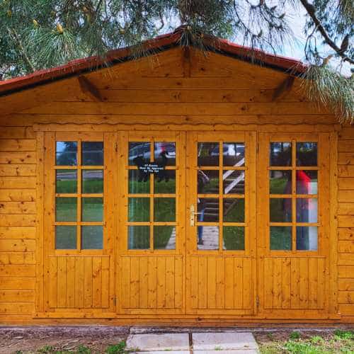 Caseta de madera con diseño rústico en la Residencia Canina Parayas, rodeada de zonas verdes.