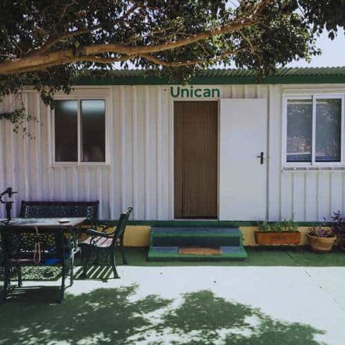 Entrada principal de la Residencia Canina Unican en Málaga, rodeada de árboles y áreas sombreadas.