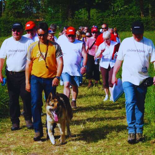 Participantes de un evento organizado por la Residencia Canina Txakur Bai en Bilbao, caminando al aire libre junto a un pastor alemán.
