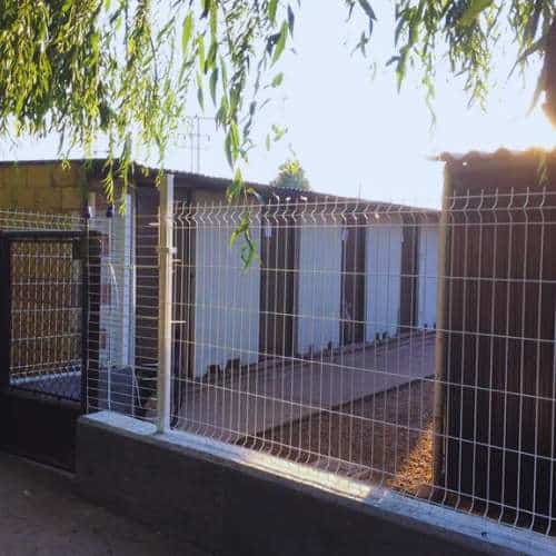 Instalaciones exteriores de la Residencia Canina Villanueva en Burgos, con jaulas seguras y un diseño limpio y funcional bajo la luz del atardecer.