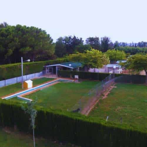 Vista aérea de las instalaciones de la Residencia Canina Don Perro y Doña Gata en Zaragoza, con amplios patios verdes y zonas cercadas.