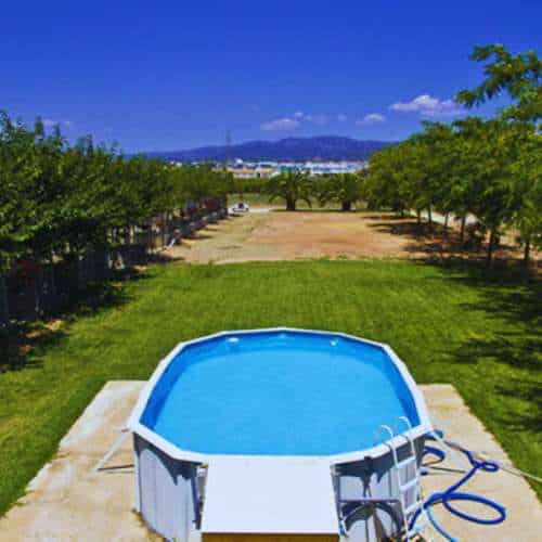 Vista de las instalaciones de la residencia canina De Pichera en Valencia, destacando una piscina para perros rodeada de un amplio espacio verde.