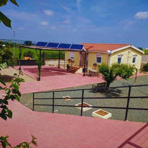 Zona principal de la Residencia Los Amigos de Erik en Guadalajara, con una casa rodeada de jardines y paneles solares.