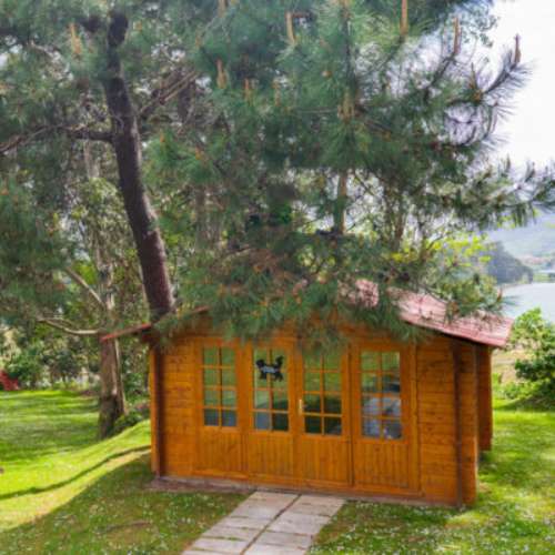 Cabaña de madera en un entorno natural dentro de la guardería canina Cecapa en Santander, ideal para la relajación de las mascotas.