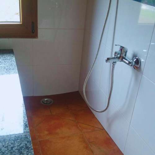 Zona de ducha en las instalaciones de la guardería canina Ovican en Oviedo, diseñada para la comodidad y limpieza de las mascotas.