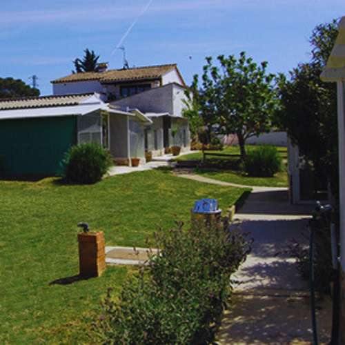 Vista de las zonas exteriores de la Residencia Can Planet en Girona, con jardines y áreas de alojamiento para mascotas.